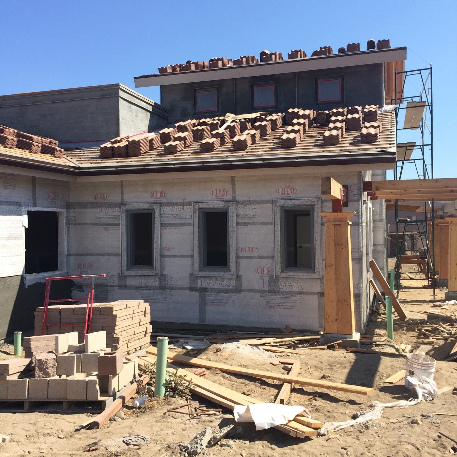 Clay roof tile staged during installation on the Mediterranean commercial building
