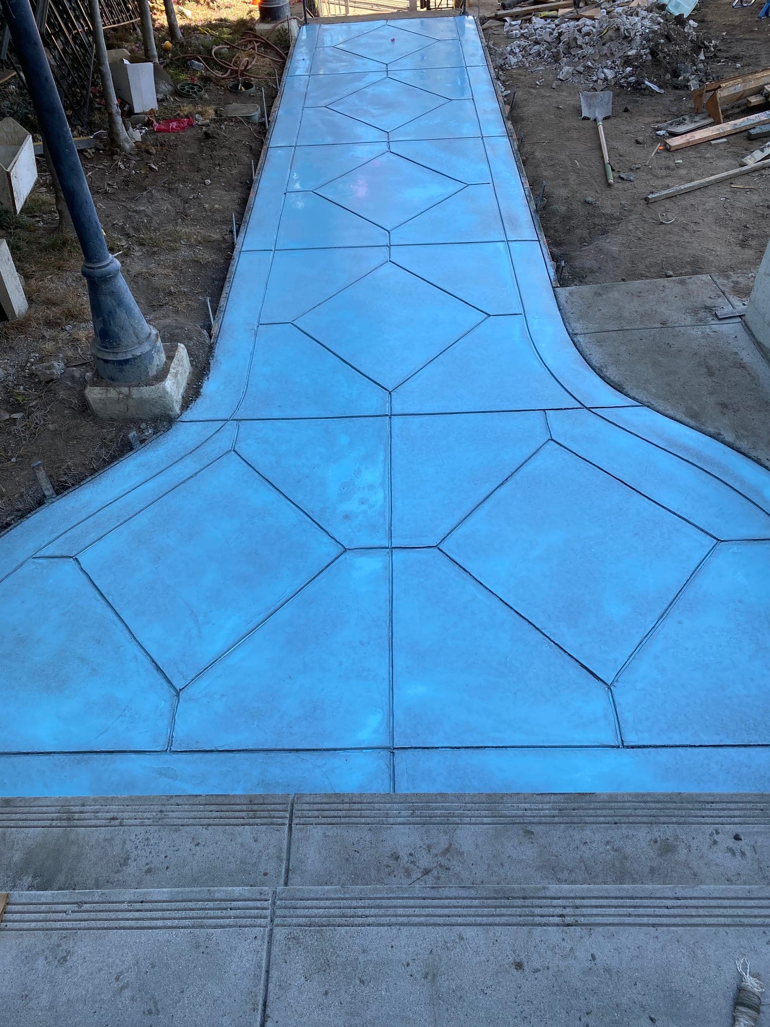 Custom scored-concrete walkway with geometric diamond pattern