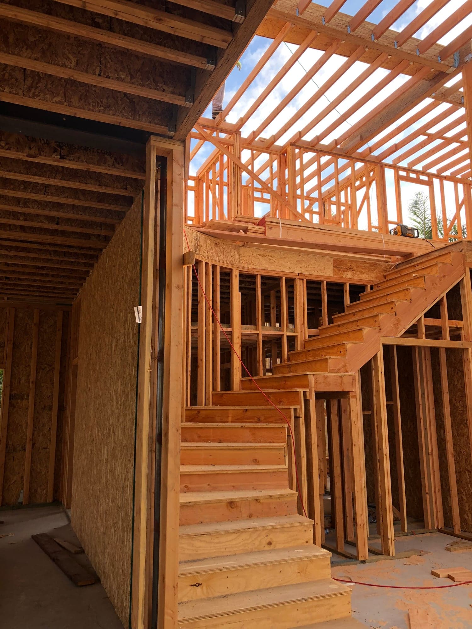 JJ's Construction job site — custom home framing and staircase under construction